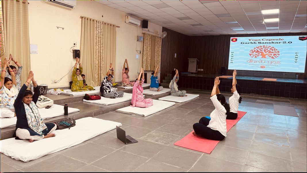 A workshop in progress, participants on mats with a presentation screen behind