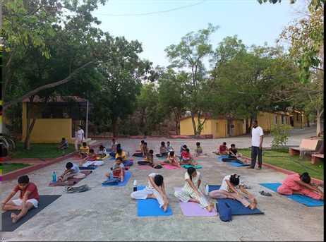 A group resting on mats under trees at the close of a session