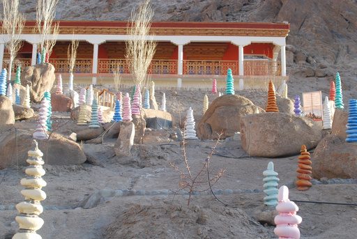 Stacked prayer stones in front of a Ladakhi monastery building
